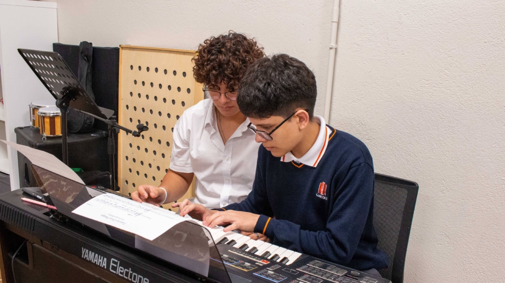 alumnos de secundaria tocando el piano en clase