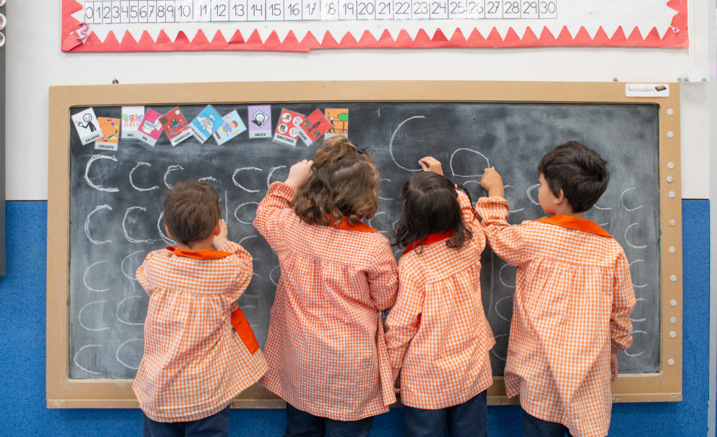 Niños en infantil aprendiendo a escribir en una pizarra la letra c